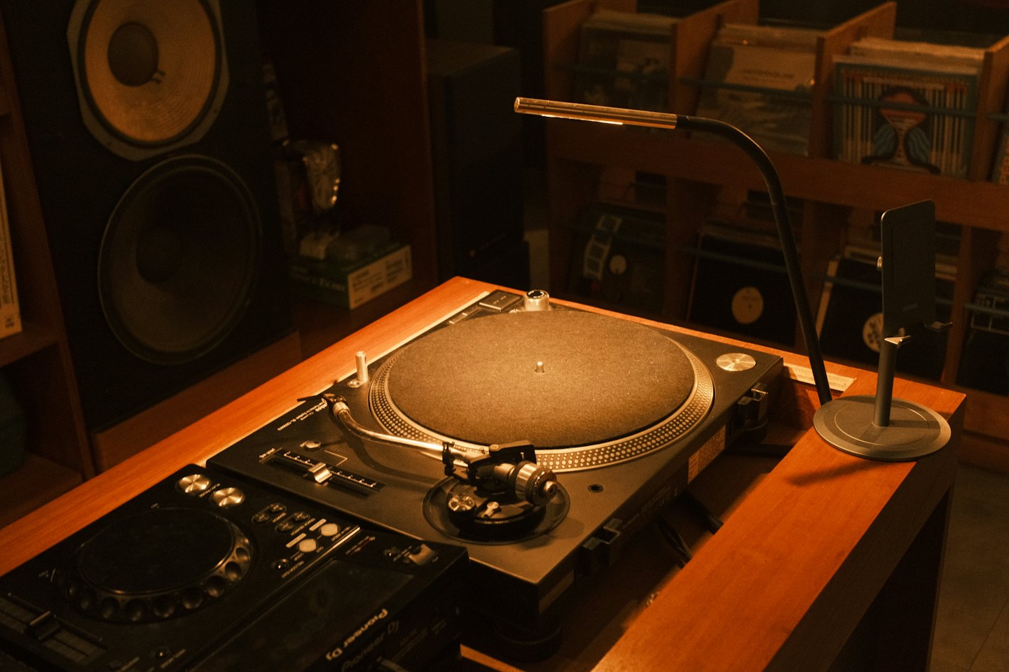 Tocadiscos y mesa de mezclas de DJ sobre una consola de madera.